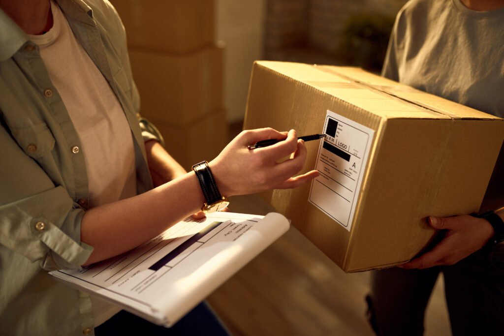 unrecognizable couriers preparing packages for a delivery in the